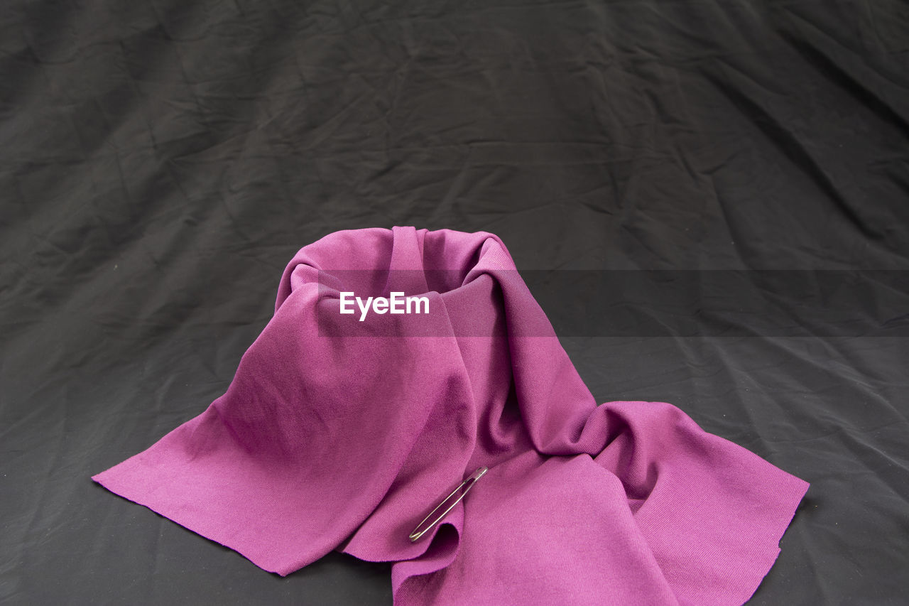 HIGH ANGLE VIEW OF PINK UMBRELLA ON BED