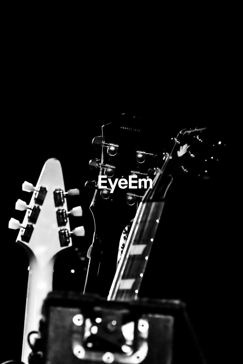 CLOSE-UP OF GUITAR IN BLACK BACKGROUND