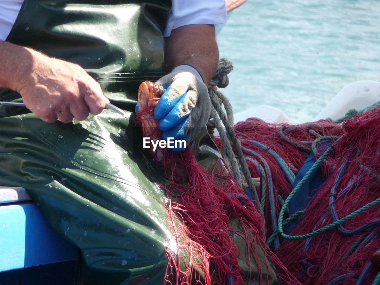Midsection of fisherman holding fishing net