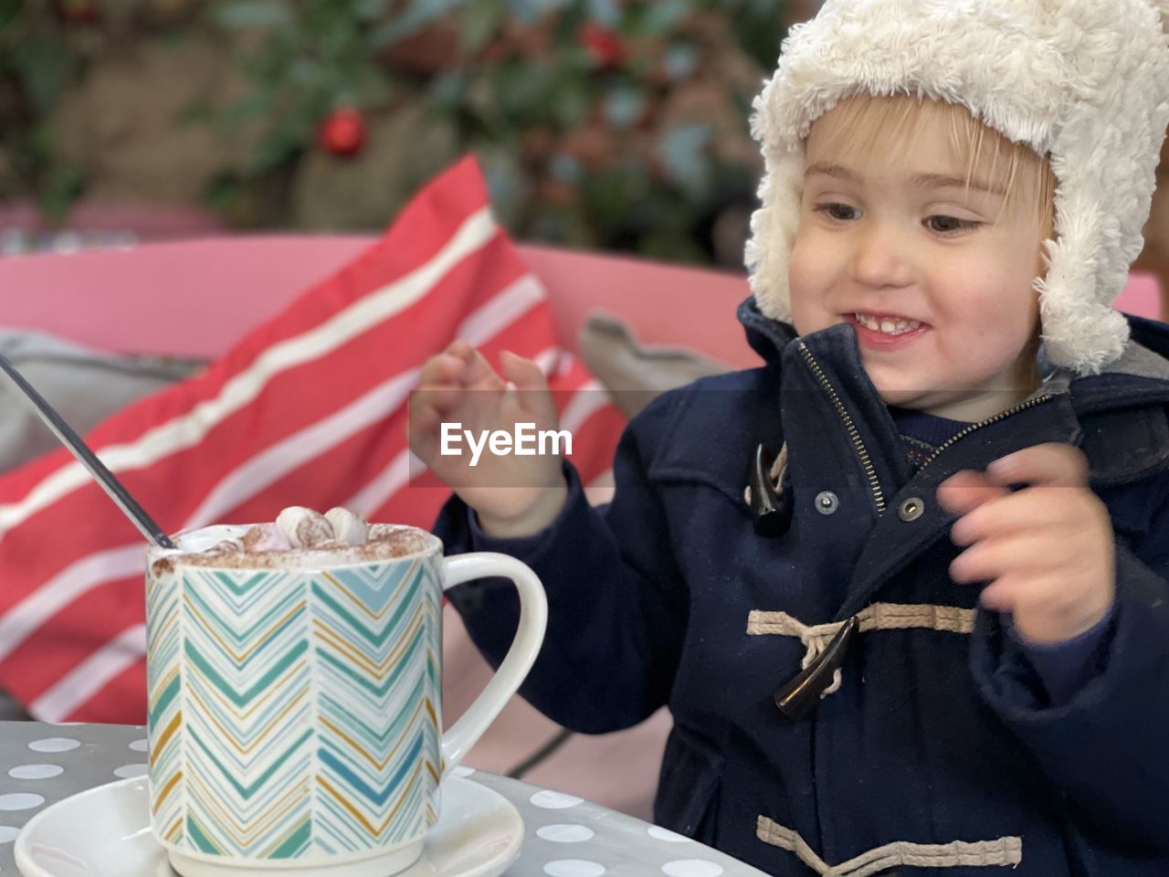 PORTRAIT OF A SMILING BOY HOLDING CAMERA WHILE STANDING OUTDOORS