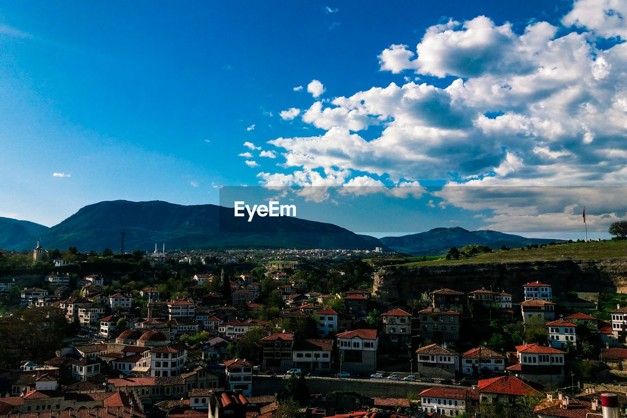 HIGH ANGLE VIEW OF TOWNSCAPE AND MOUNTAIN AGAINST SKY