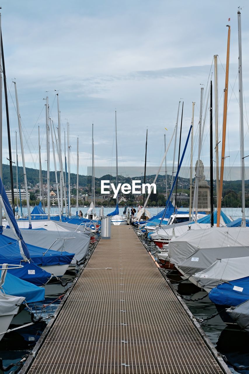 marina, nautical vessel, water, dock, transportation, sailboat, sea, sky, mode of transportation, moored, mast, pole, nature, boat, harbor, sailing, cloud, no people, vehicle, day, pier, ship, travel, outdoors, tranquility, in a row, the way forward, watercraft, beauty in nature, travel destinations, beach, architecture, land, blue