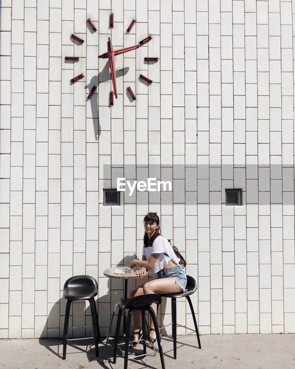 MAN SITTING ON CHAIR AGAINST TABLE