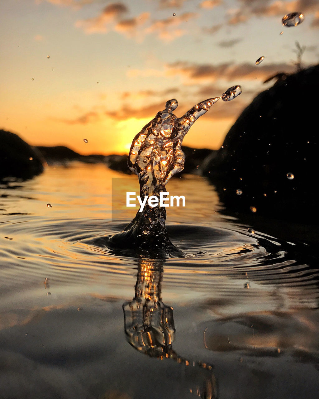 CLOSE-UP OF WATER SPLASHING ON LAKE DURING SUNSET