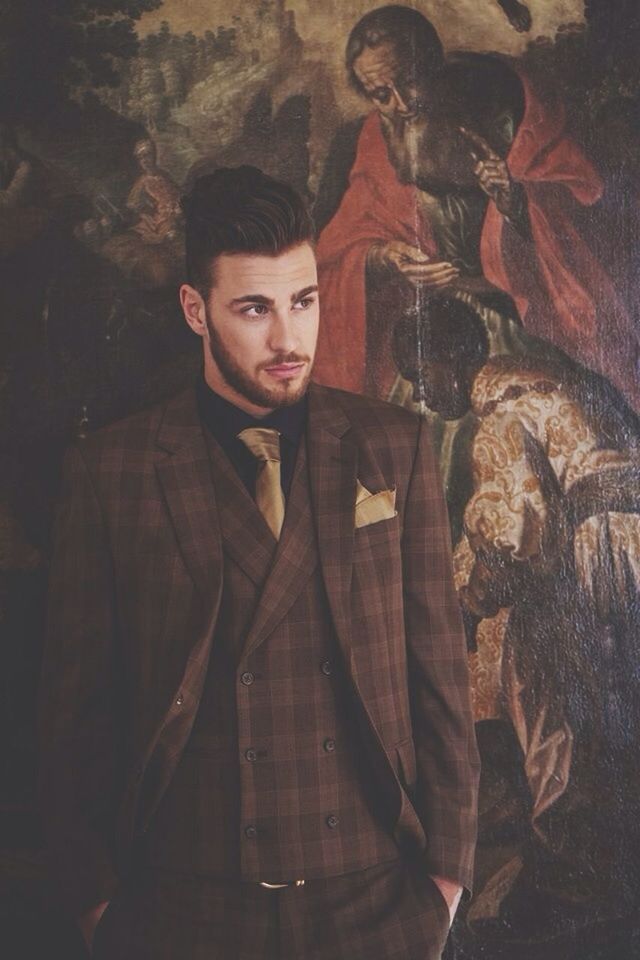 Handsome mid adult man standing against painting