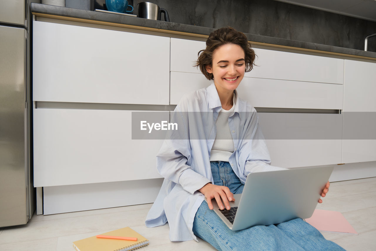 portrait of young businesswoman using laptop while sitting on table