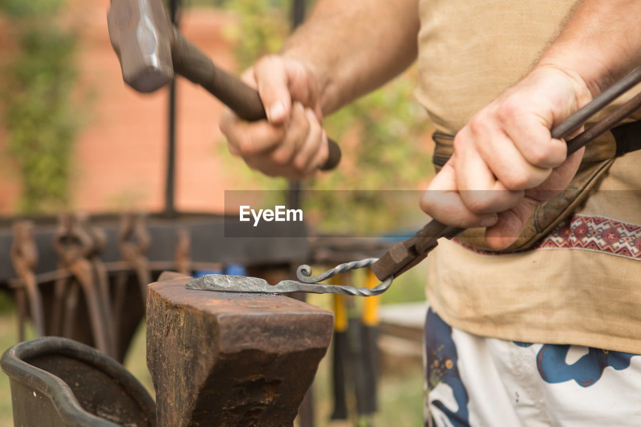 Midsection of man working at workshop