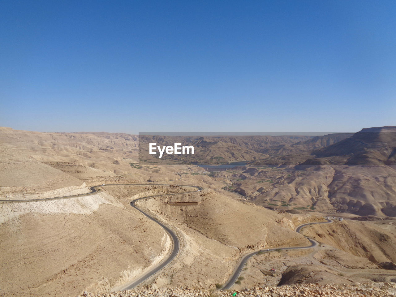 Scenic view of desert against clear blue sky