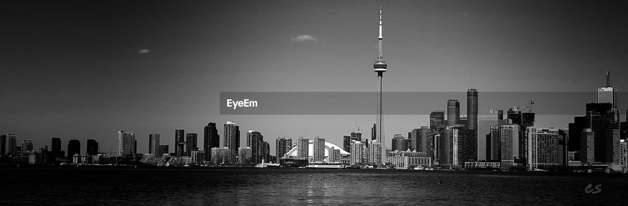 Panoramic shot of cn tower with city skyline by river