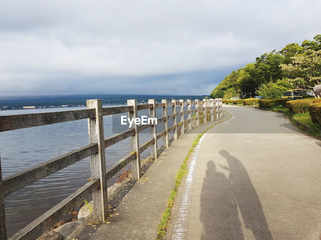 Empty road by sea against sky