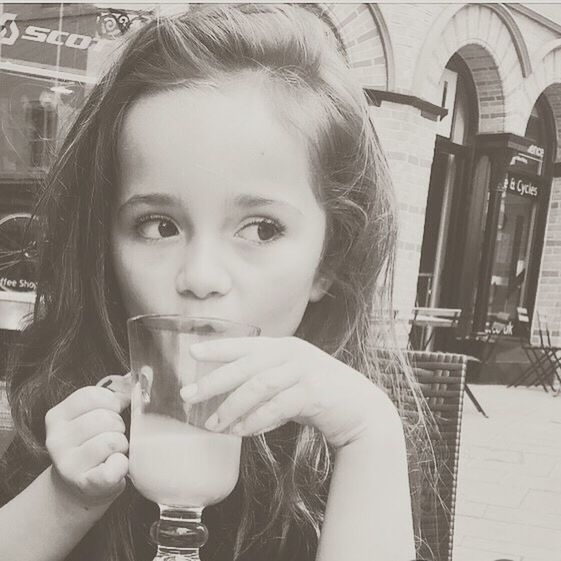 CLOSE-UP PORTRAIT OF HAPPY YOUNG WOMAN DRINKING GLASS