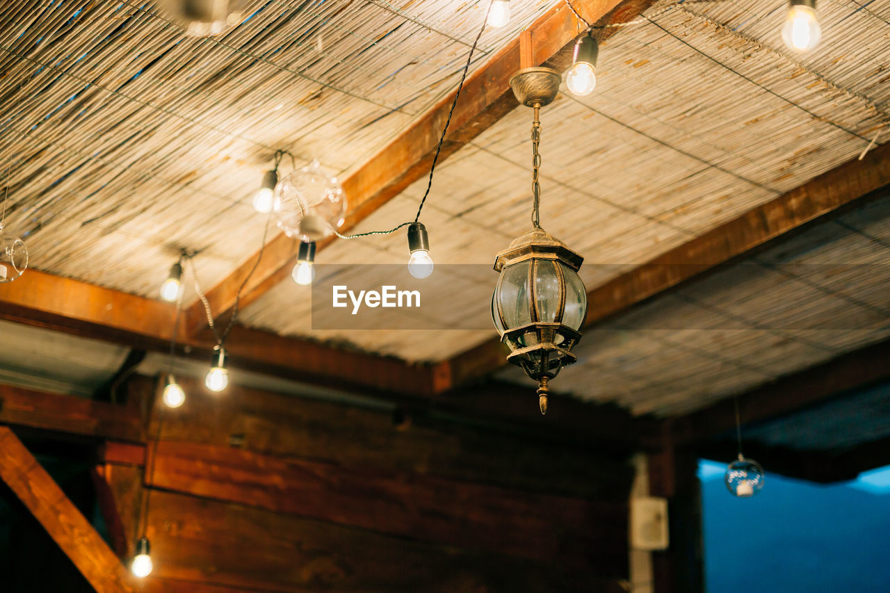 Low angle view of illuminated pendant light hanging from ceiling