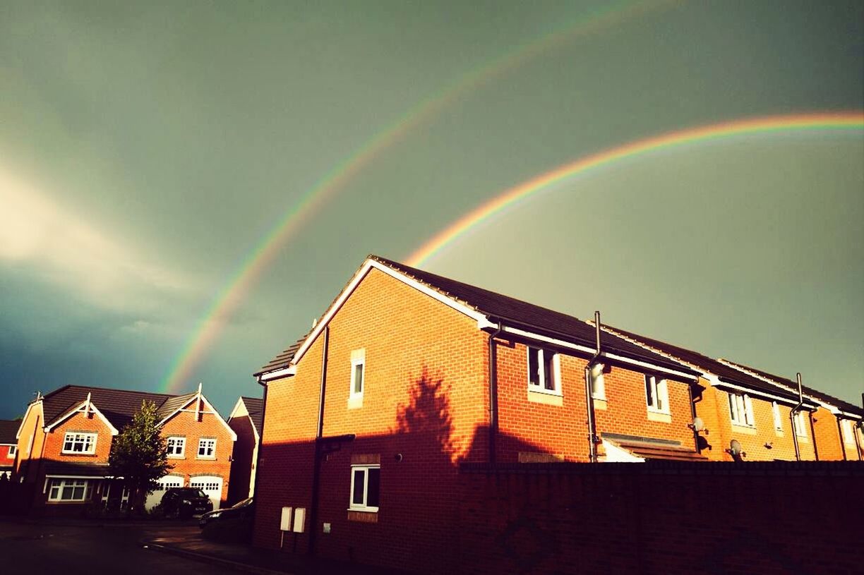 RAINBOW OVER BUILDINGS AGAINST SKY