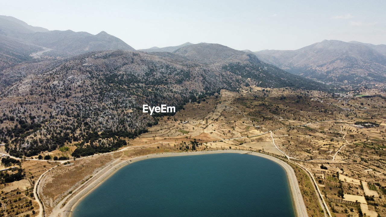 Aerial view of land and mountains against sky