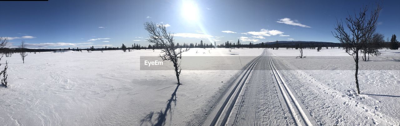 SNOW COVERED RAILROAD TRACK AGAINST SKY