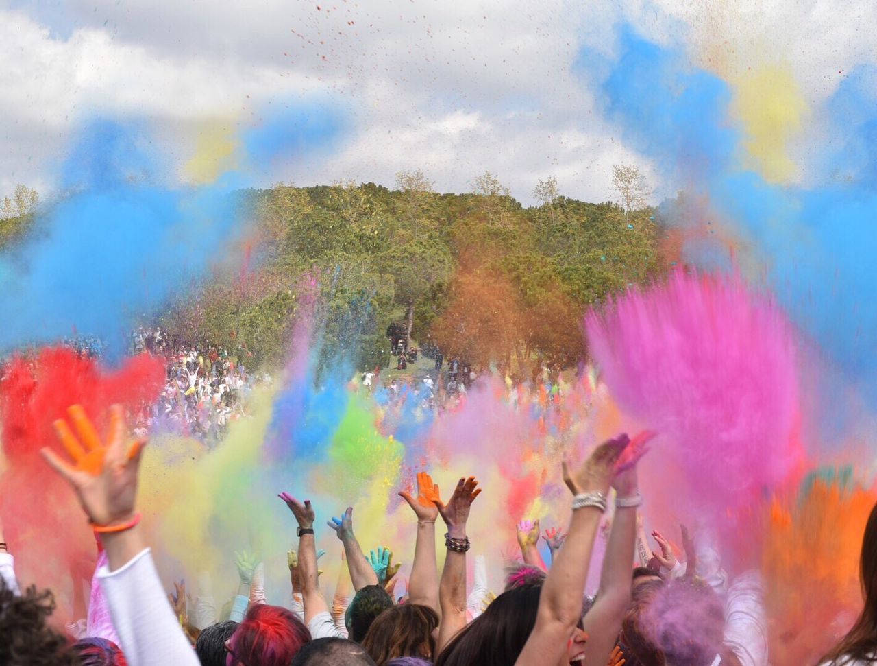 People enjoying holi against sky