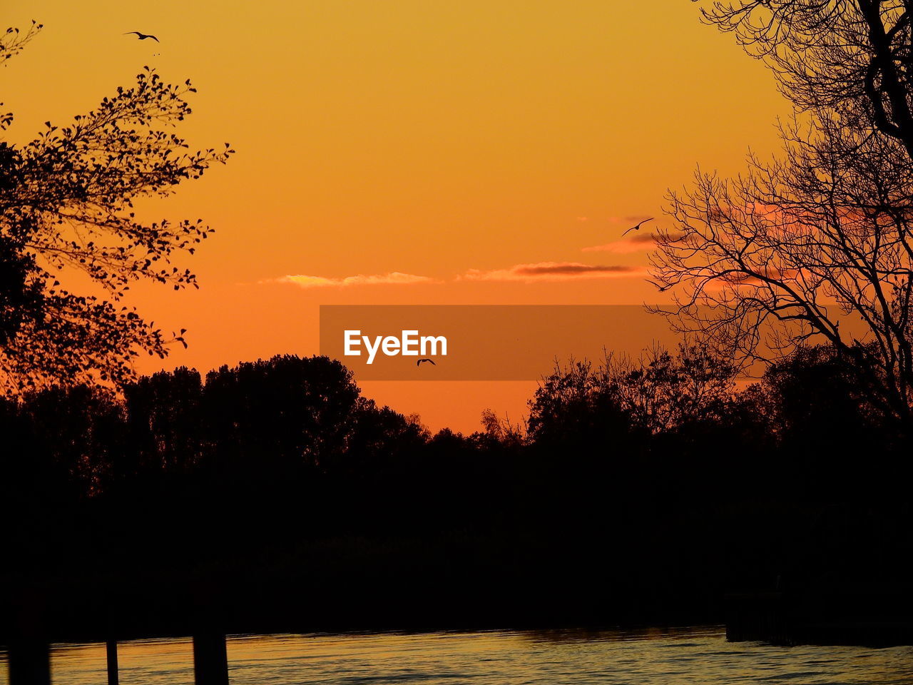 SCENIC VIEW OF LAKE AGAINST ORANGE SKY