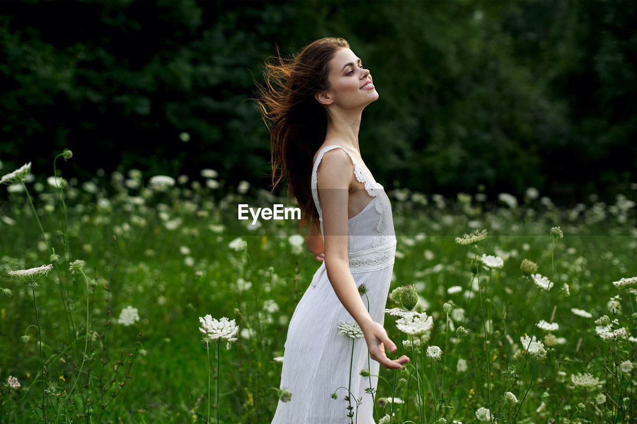 portrait of young woman standing on field