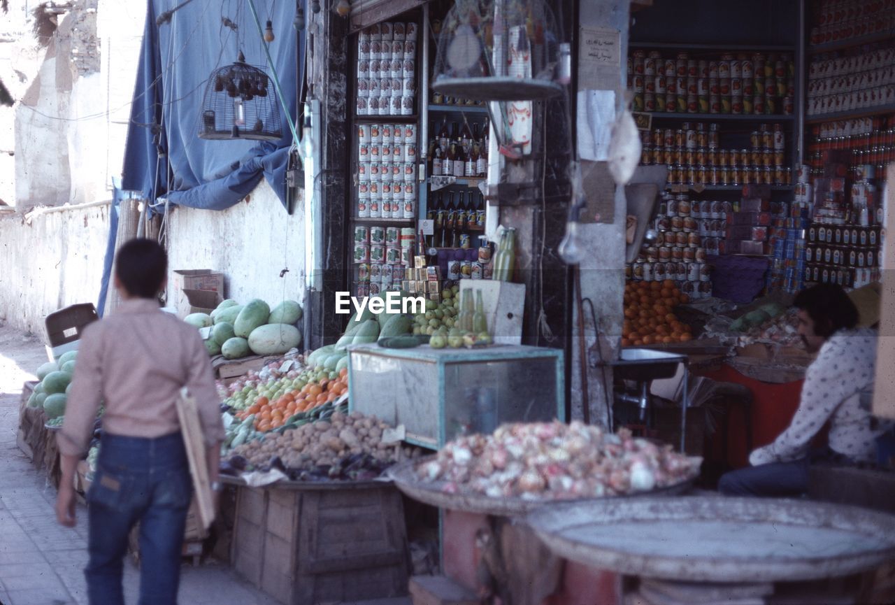 REAR VIEW OF PEOPLE IN MARKET STALL