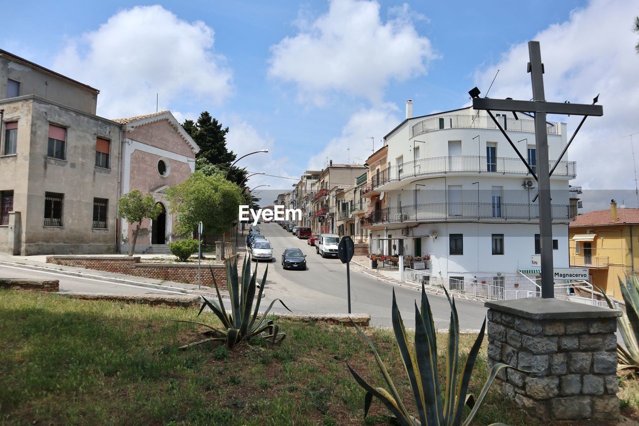 architecture, building exterior, town, built structure, building, sky, house, cloud, neighbourhood, nature, estate, residential district, city, residential area, vacation, plant, village, urban area, waterway, street, no people, transportation, day, travel destinations, outdoors, home, mode of transportation, travel, water, grass, tree, tourism, history