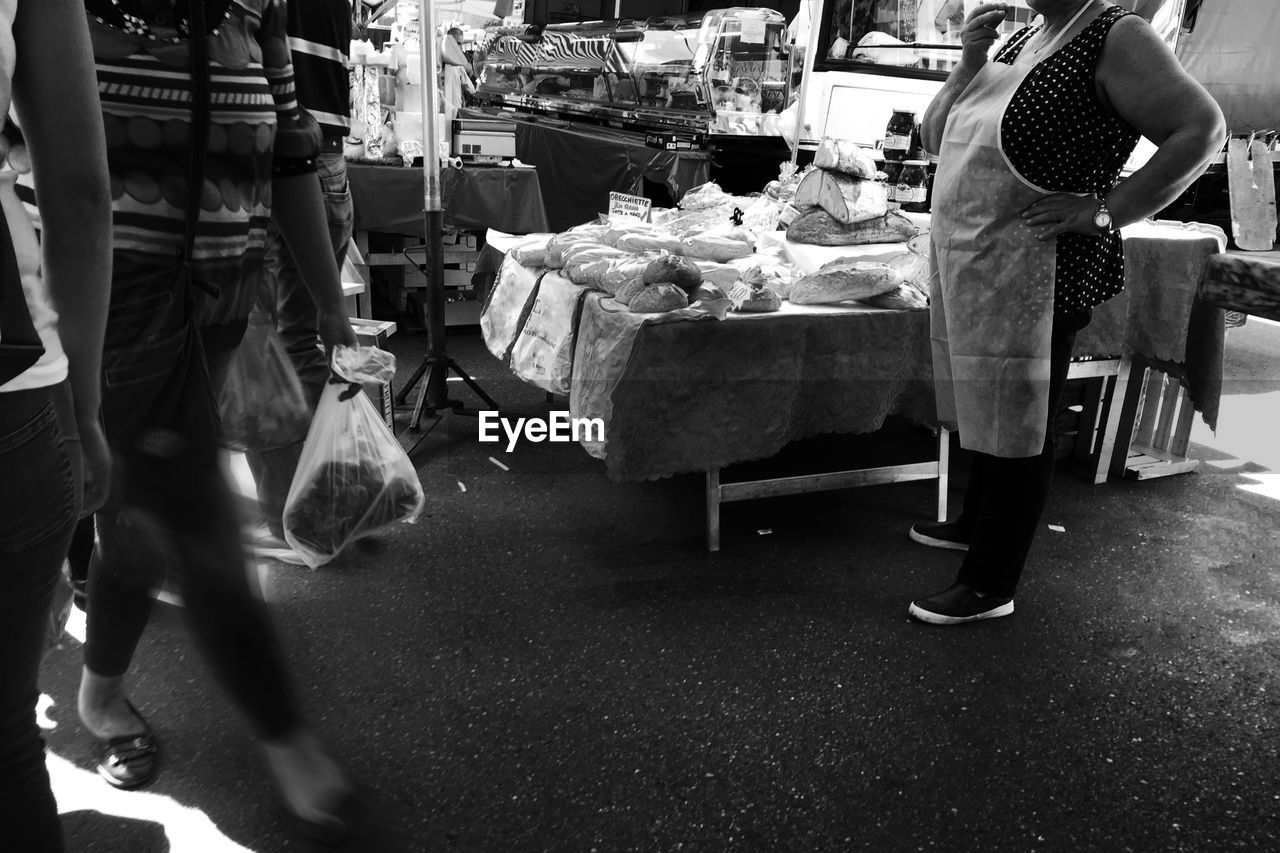 LOW SECTION OF MAN STANDING AT MARKET