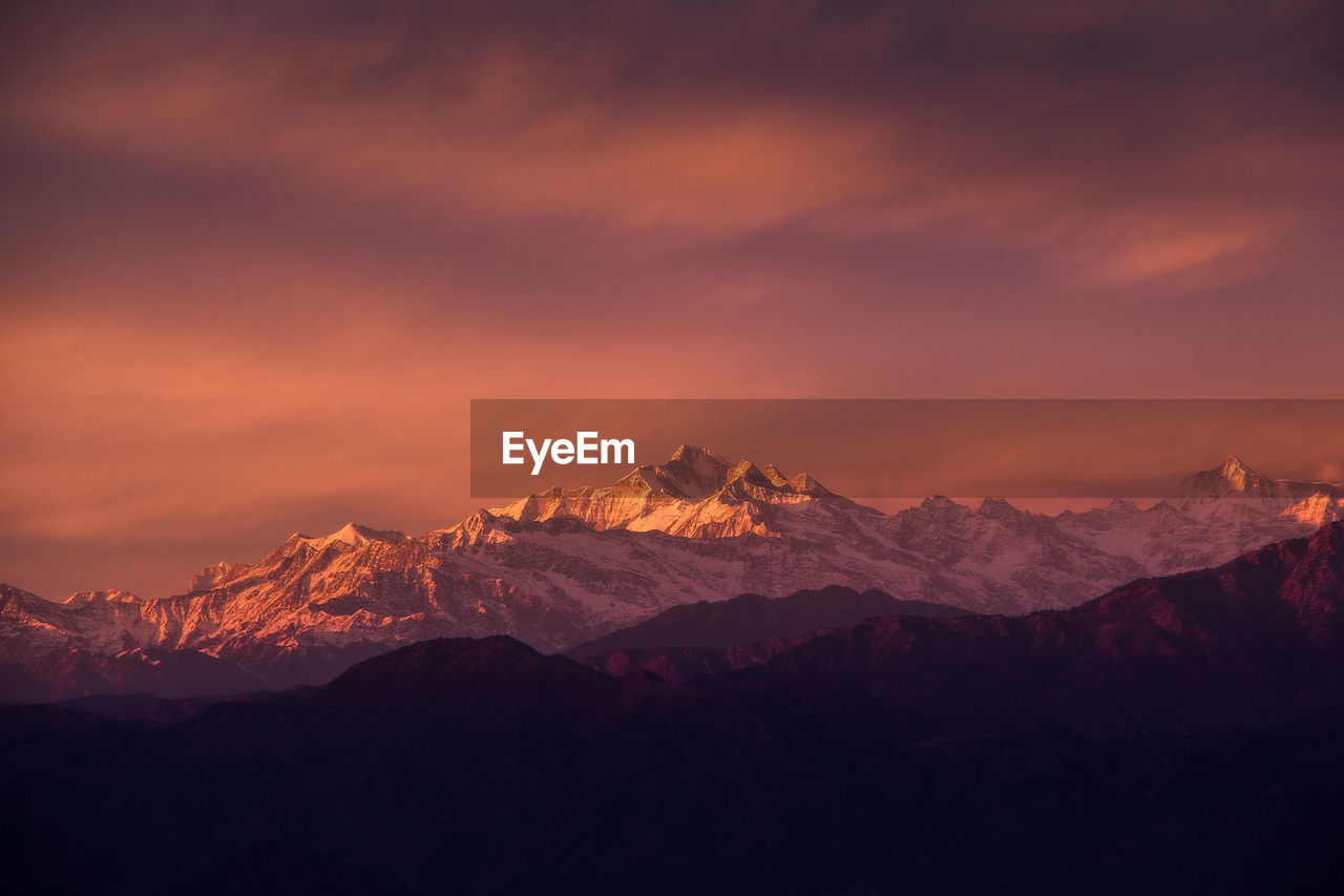 Scenic view of snowcapped mountains against sky during sunset