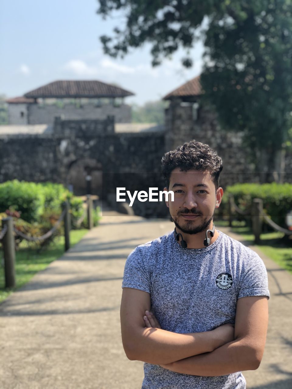 Portrait of young man standing against built structure