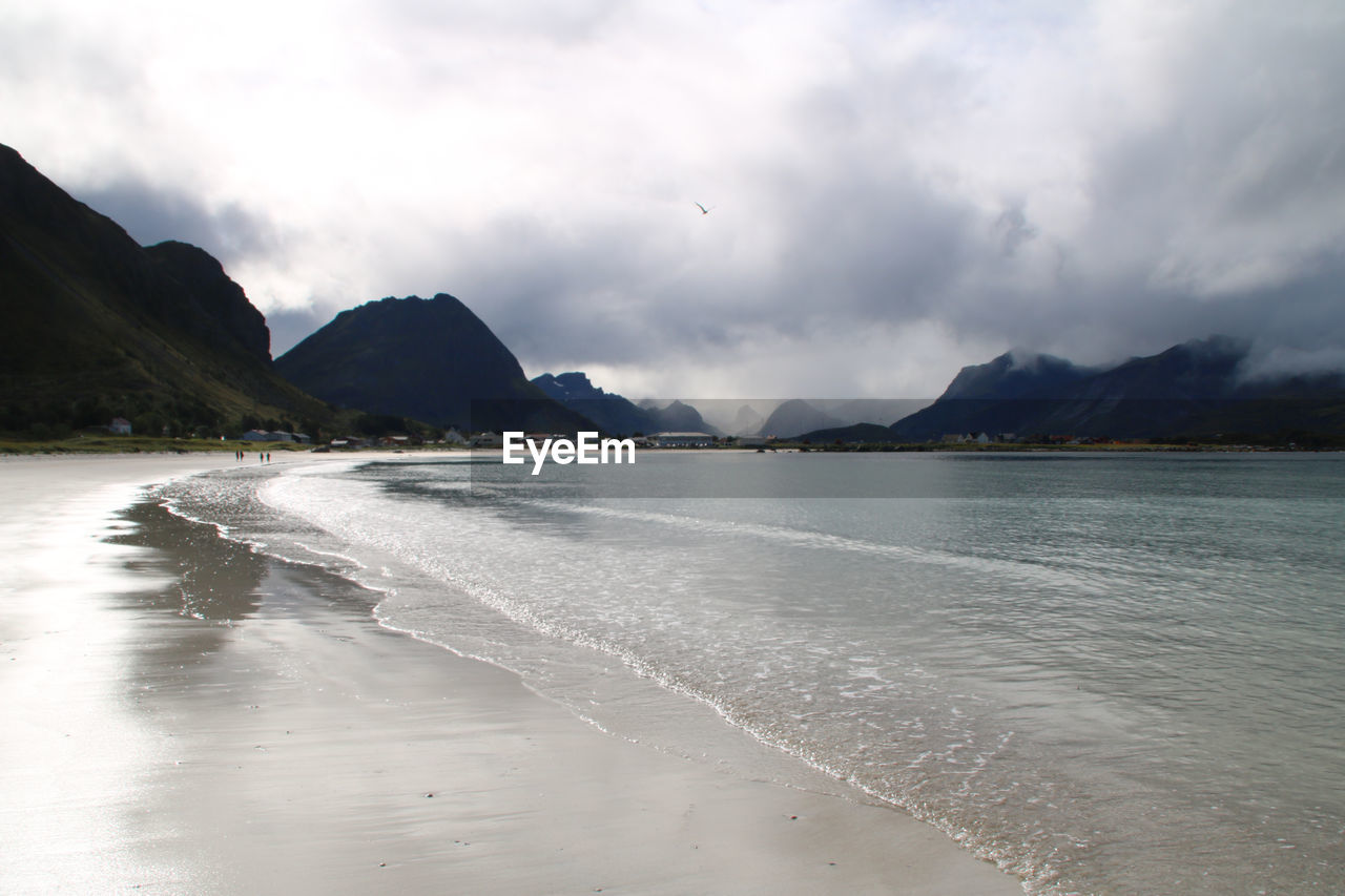 SCENIC VIEW OF BEACH BY MOUNTAINS AGAINST SKY