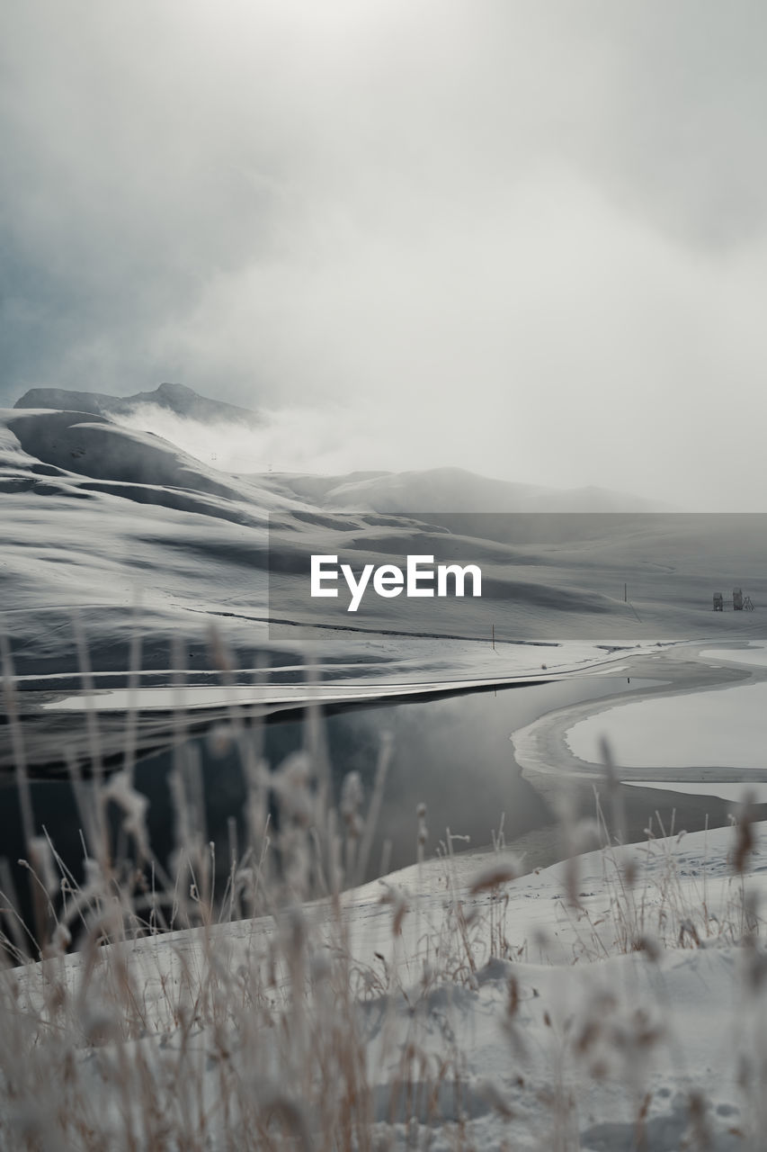 Scenic view of lake against sky during winter