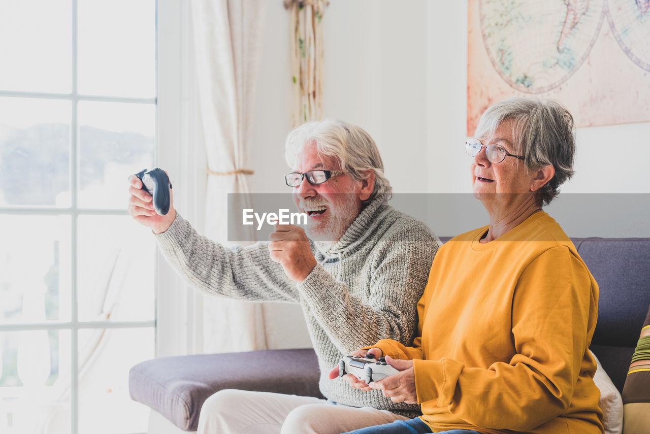 PEOPLE SITTING IN FRONT OF MAN HOLDING EYEGLASSES