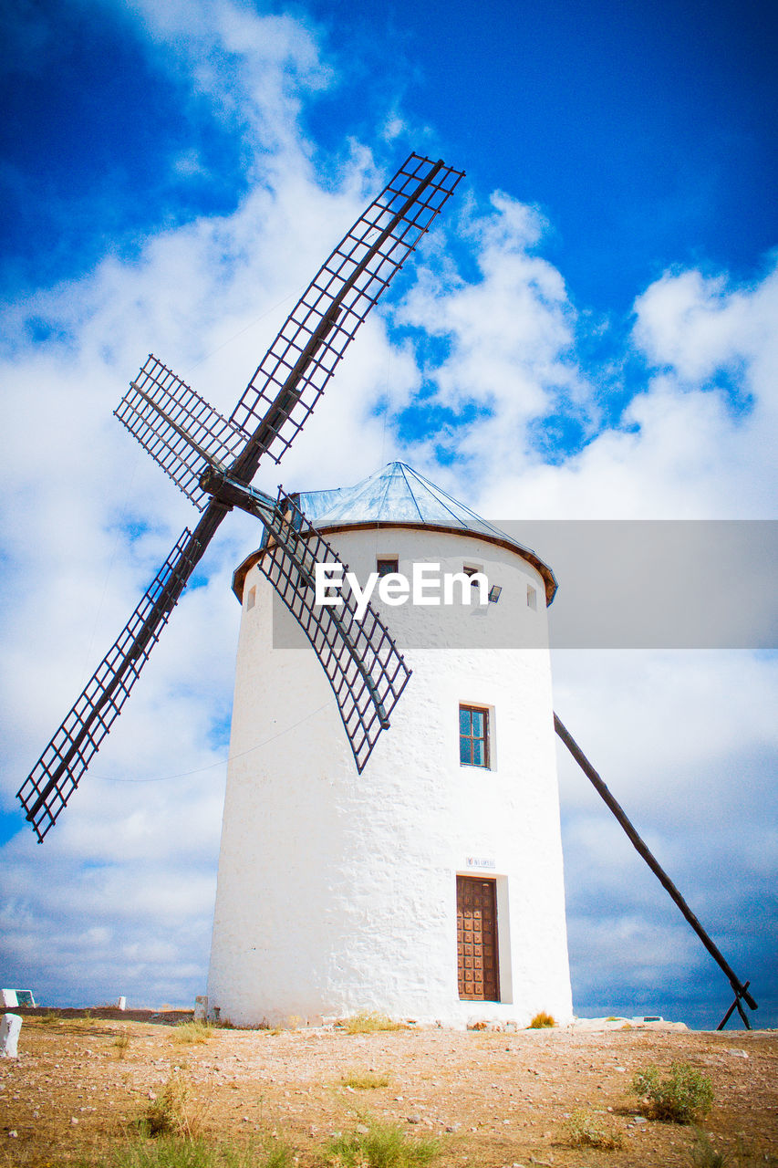 Whitewashed traditional windmill against sky