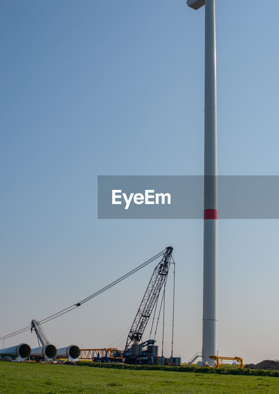 LOW ANGLE VIEW OF WINDMILLS AGAINST CLEAR SKY