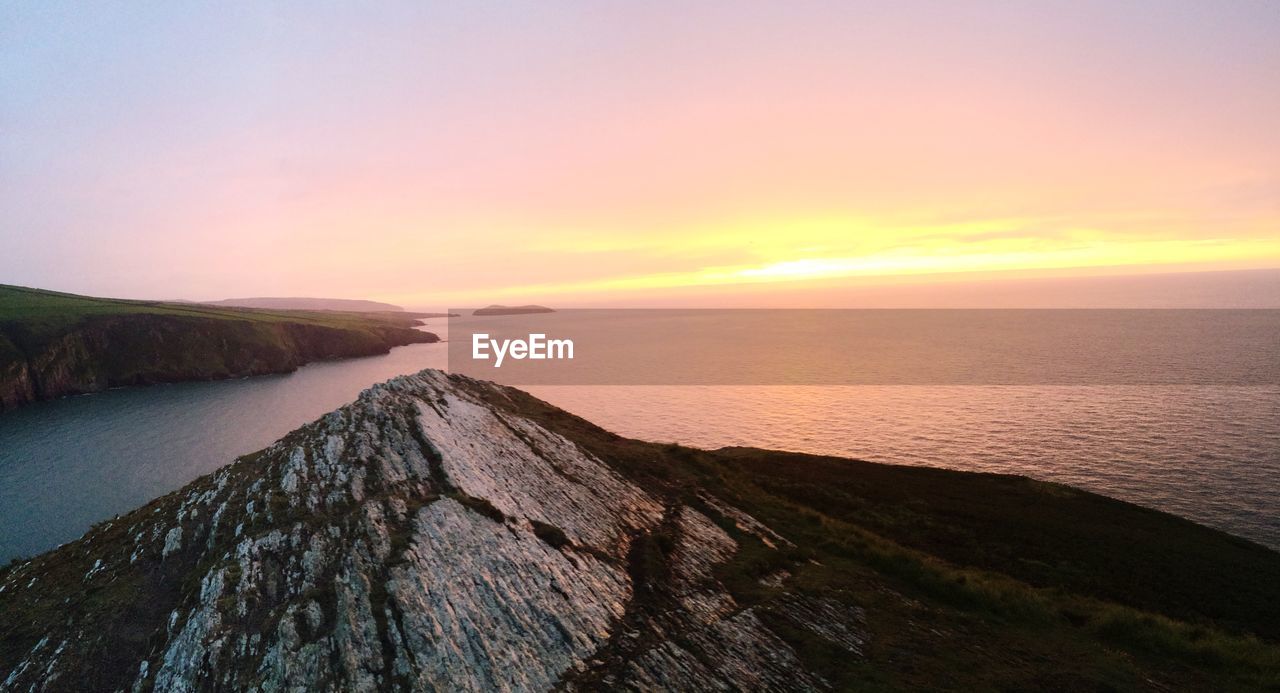 Scenic view of mountains and sea against sky during sunset