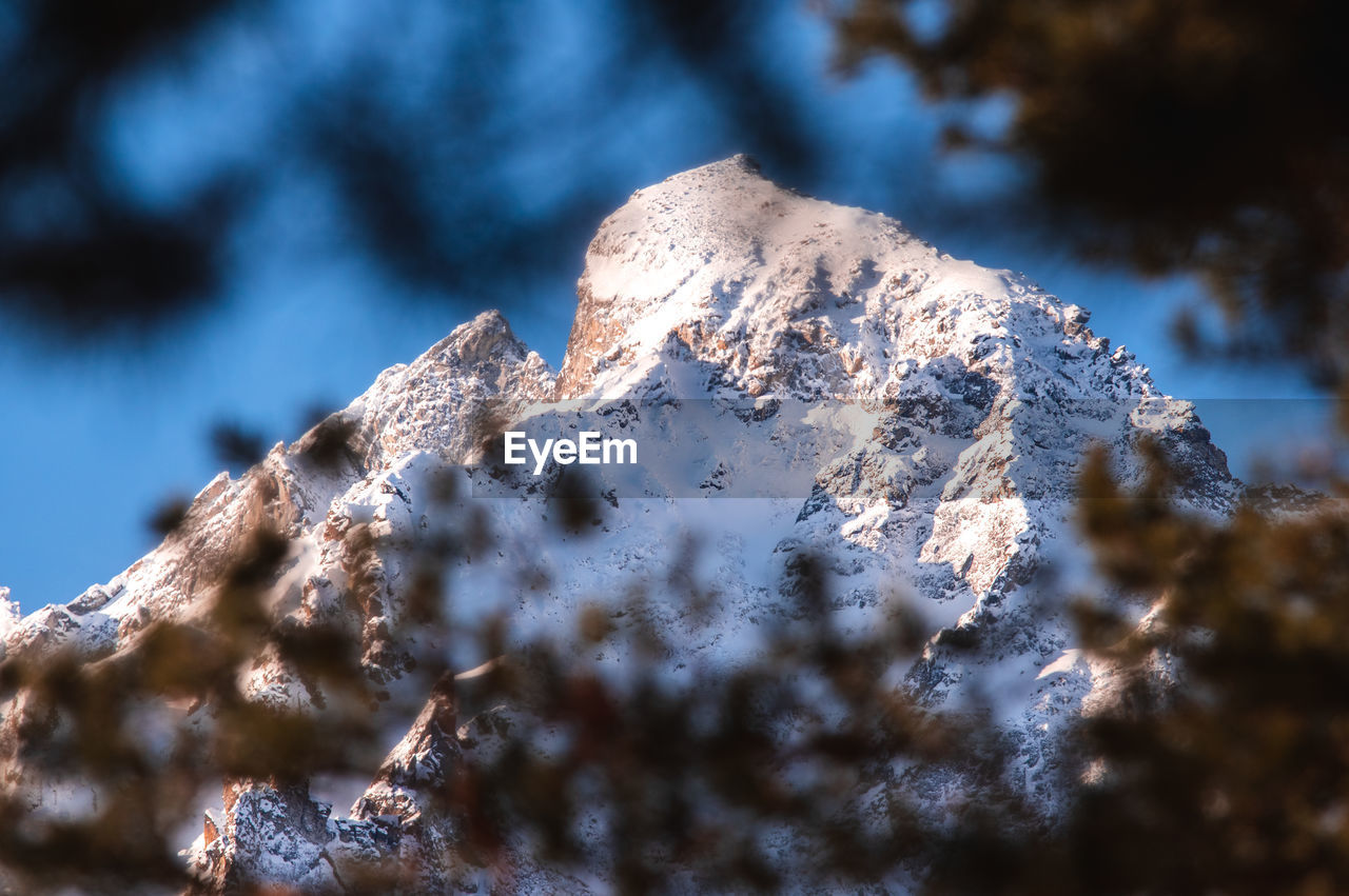 Low angle view of a snowy mountain peak against clean sky