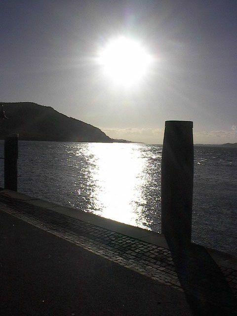 SUN SHINING THROUGH CLOUDS OVER SEA