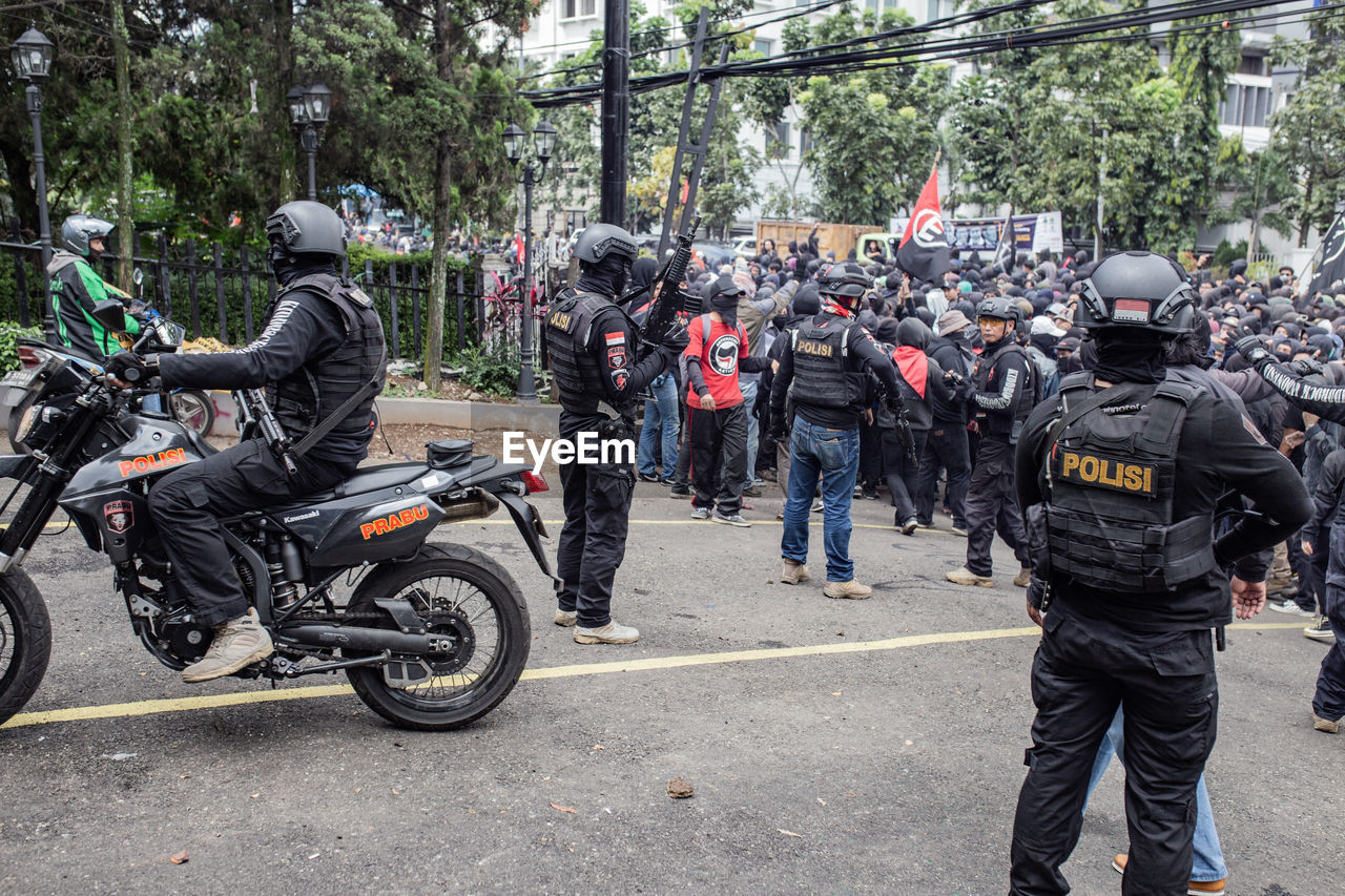 GROUP OF PEOPLE RIDING MOTORCYCLE ON CITY STREET