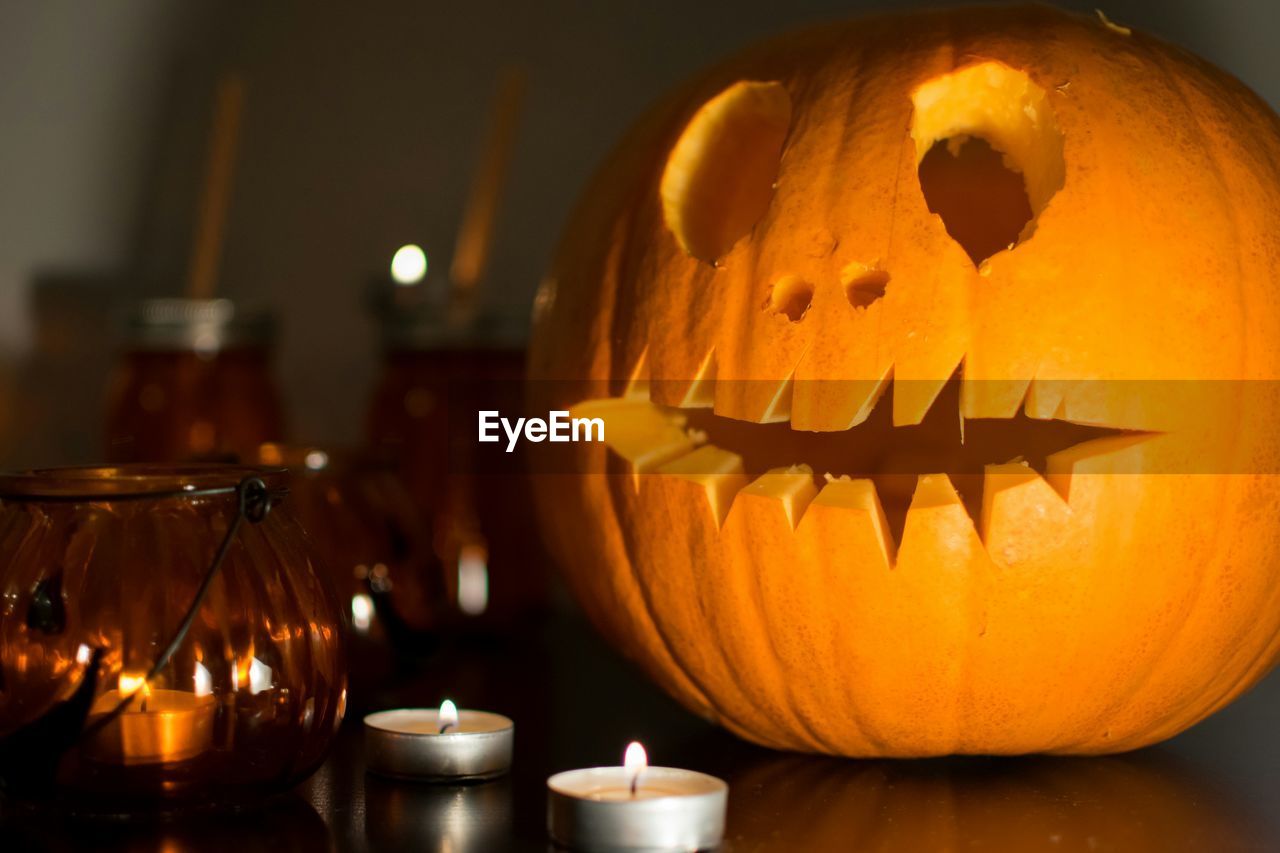 Close-up of illuminated helloween pumpkin on a wooden table