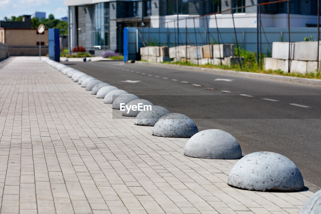 Concrete hemispheres separate the carriageway and the pedestrian walkway on the way . 