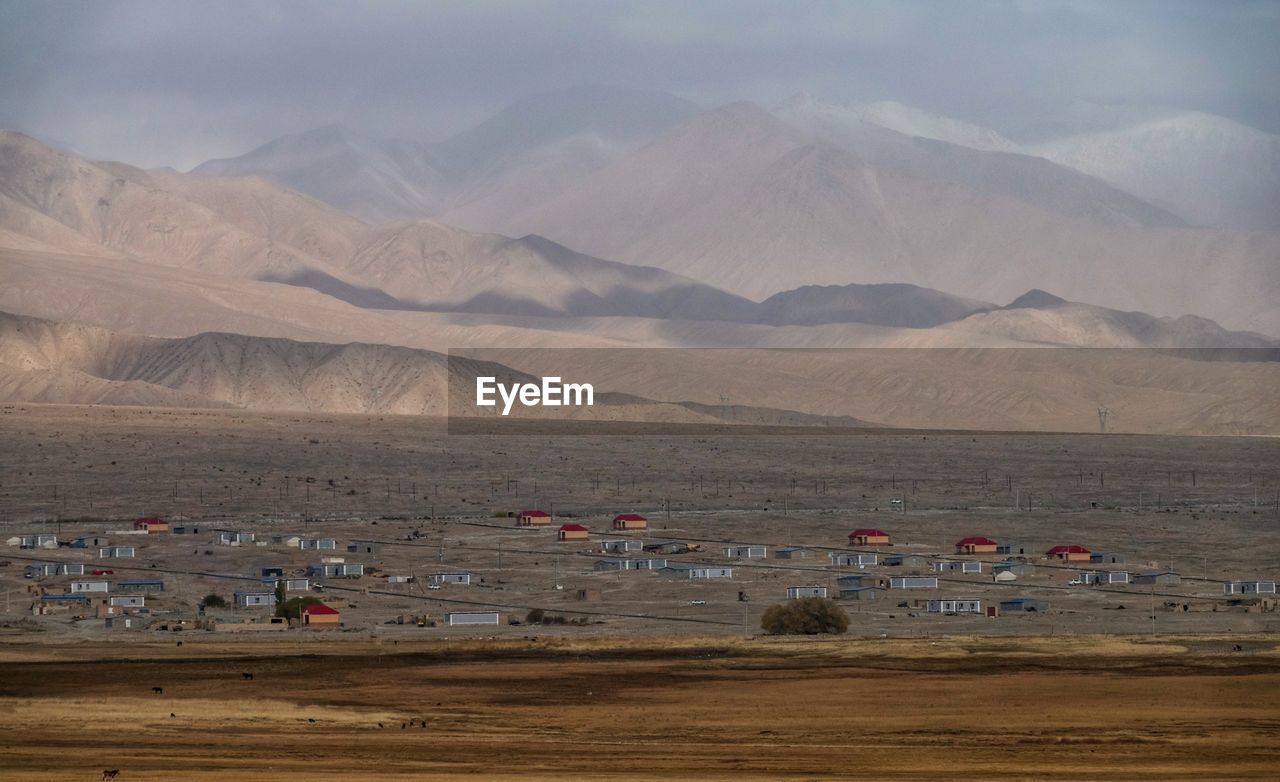 Scenic view of land and mountains against sky