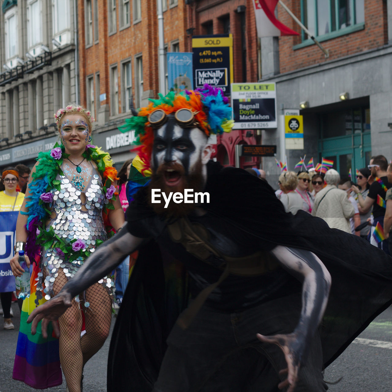 PORTRAIT OF WOMAN WITH ARMS MASK IN CITY IN BACKGROUND