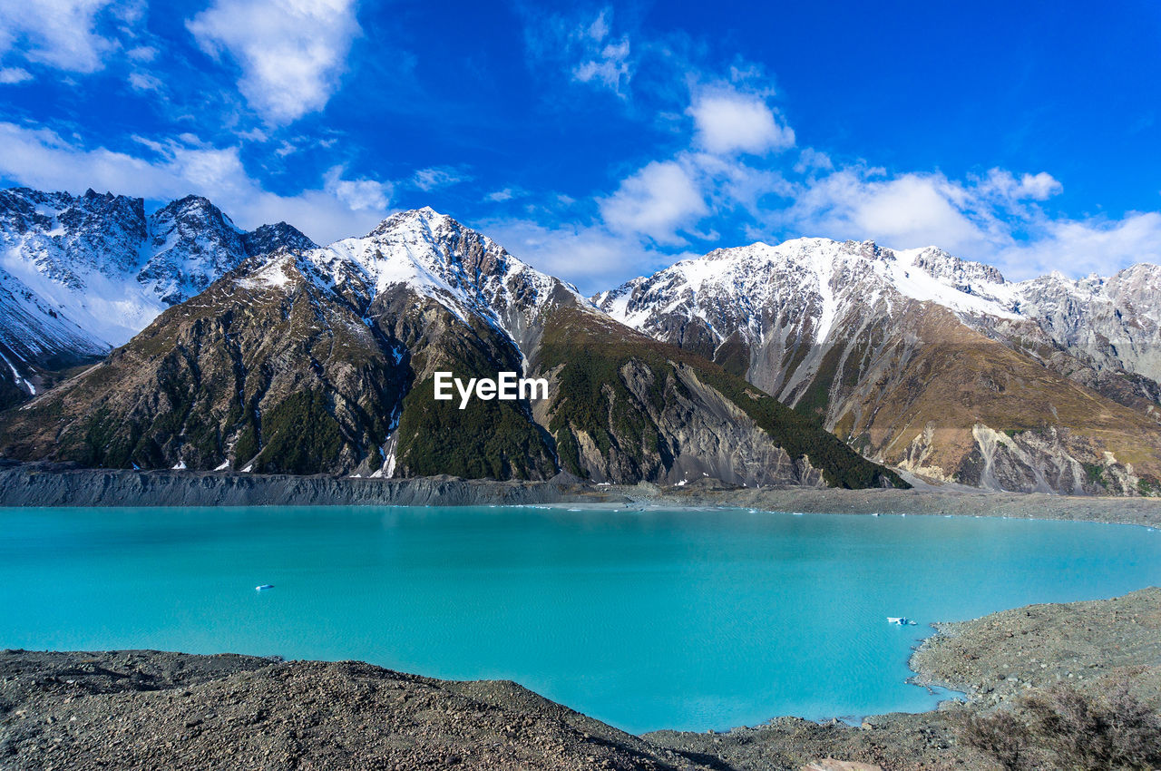 Scenic view of lake by mountains against sky