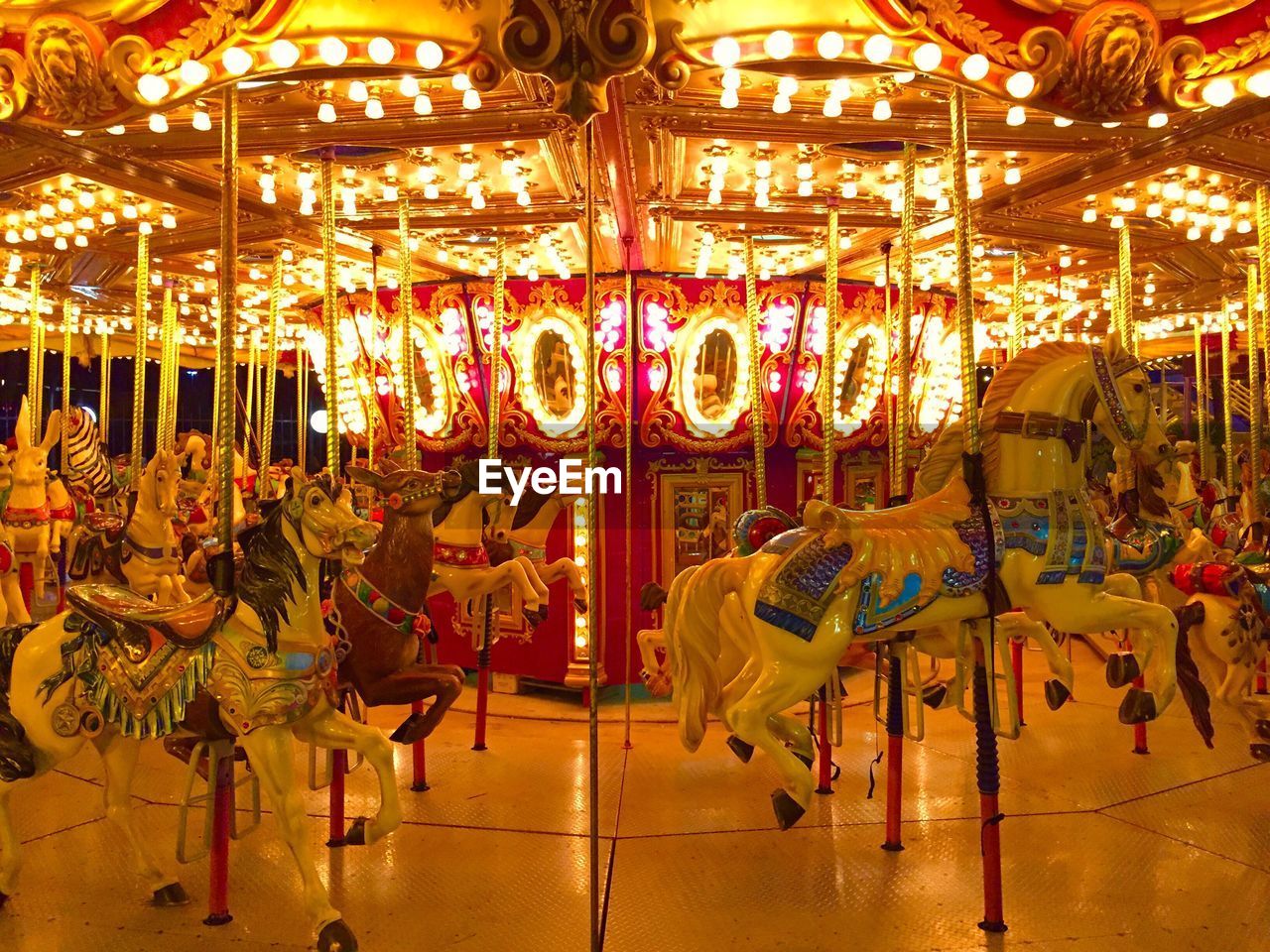 Illuminated carousel at amusement park during night