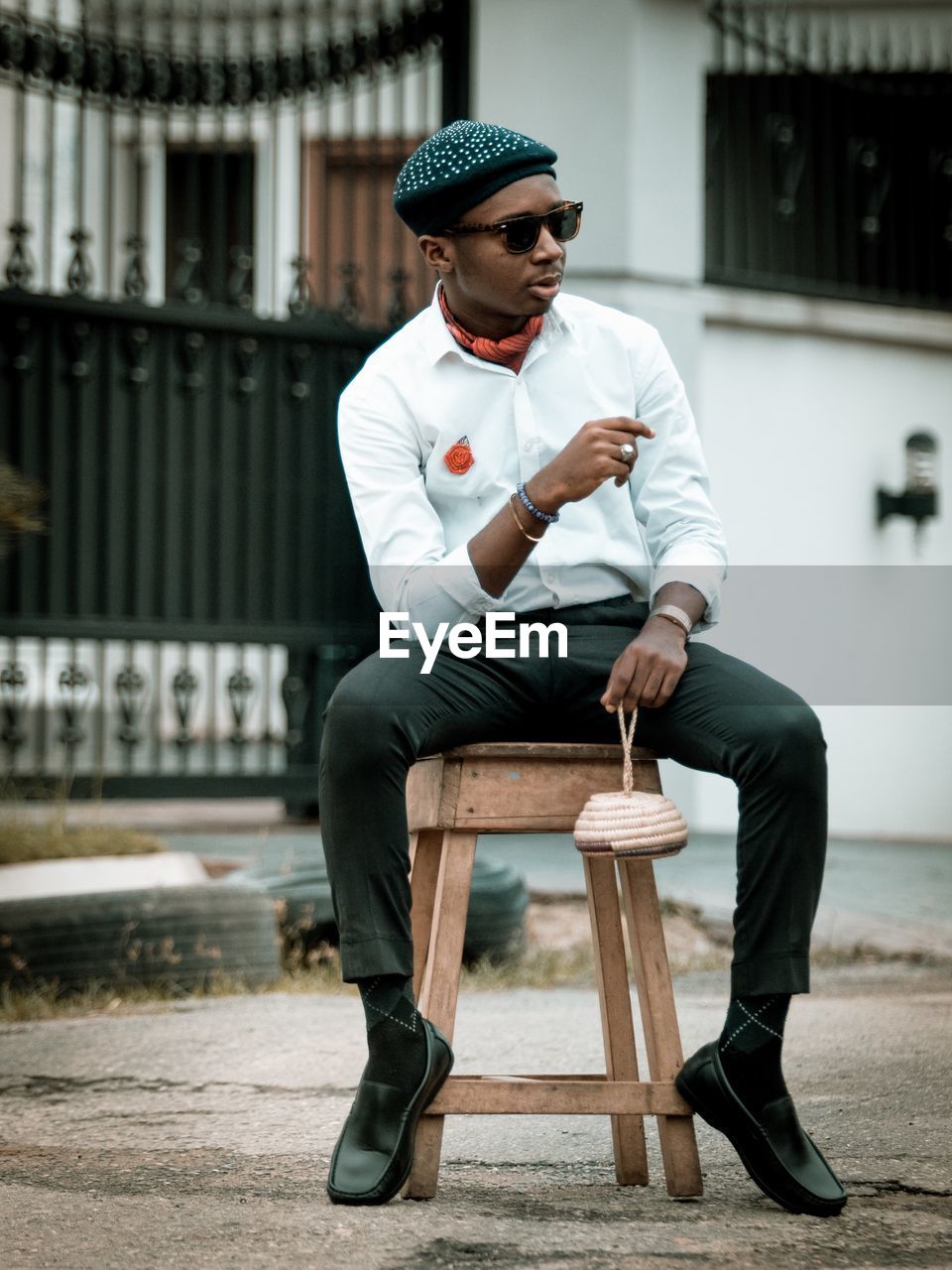 Full length of young man sitting on stool