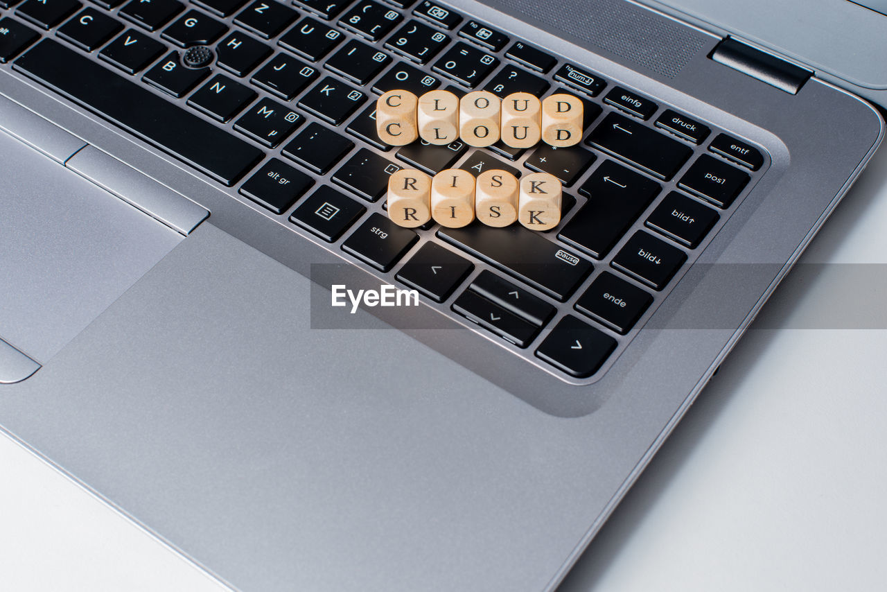 High angle view of alphabets in wooden blocks on laptop keyboard