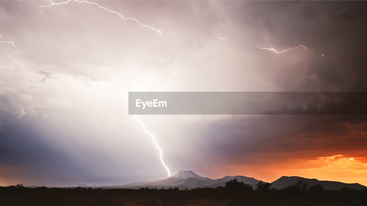 Lightning thunder and storm over city in purple light