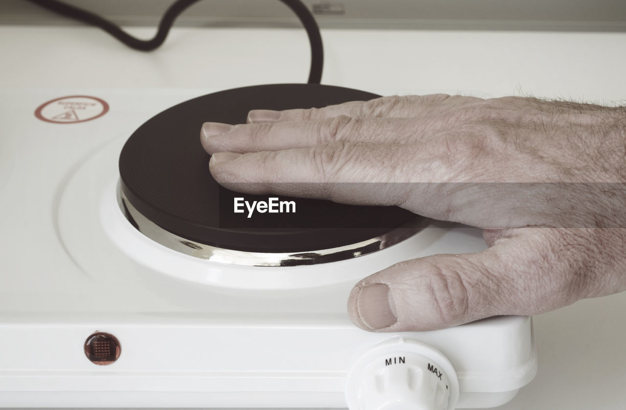 Cropped image of hand pushing switch of electrical equipment