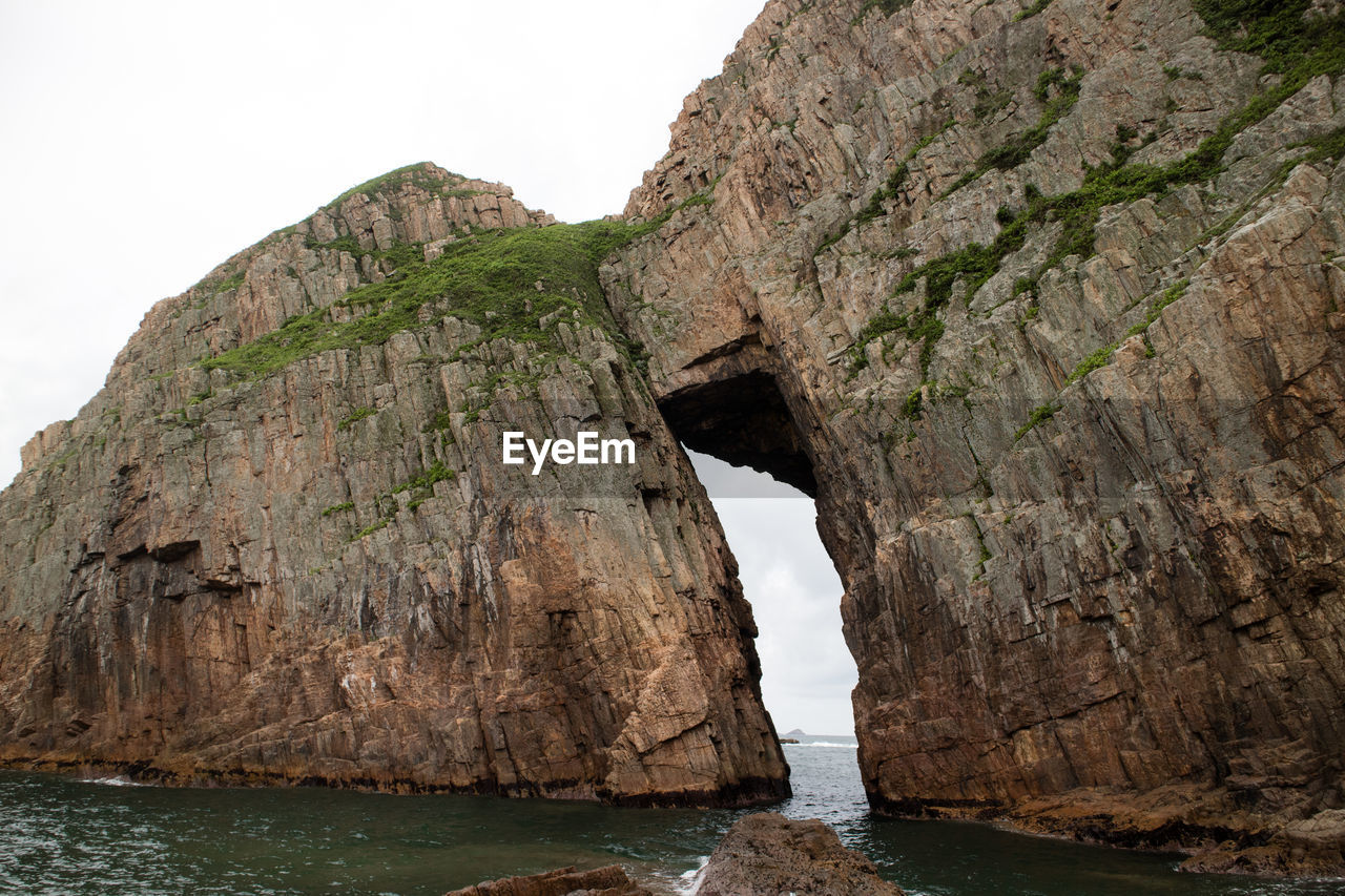 Rock formations by sea against sky