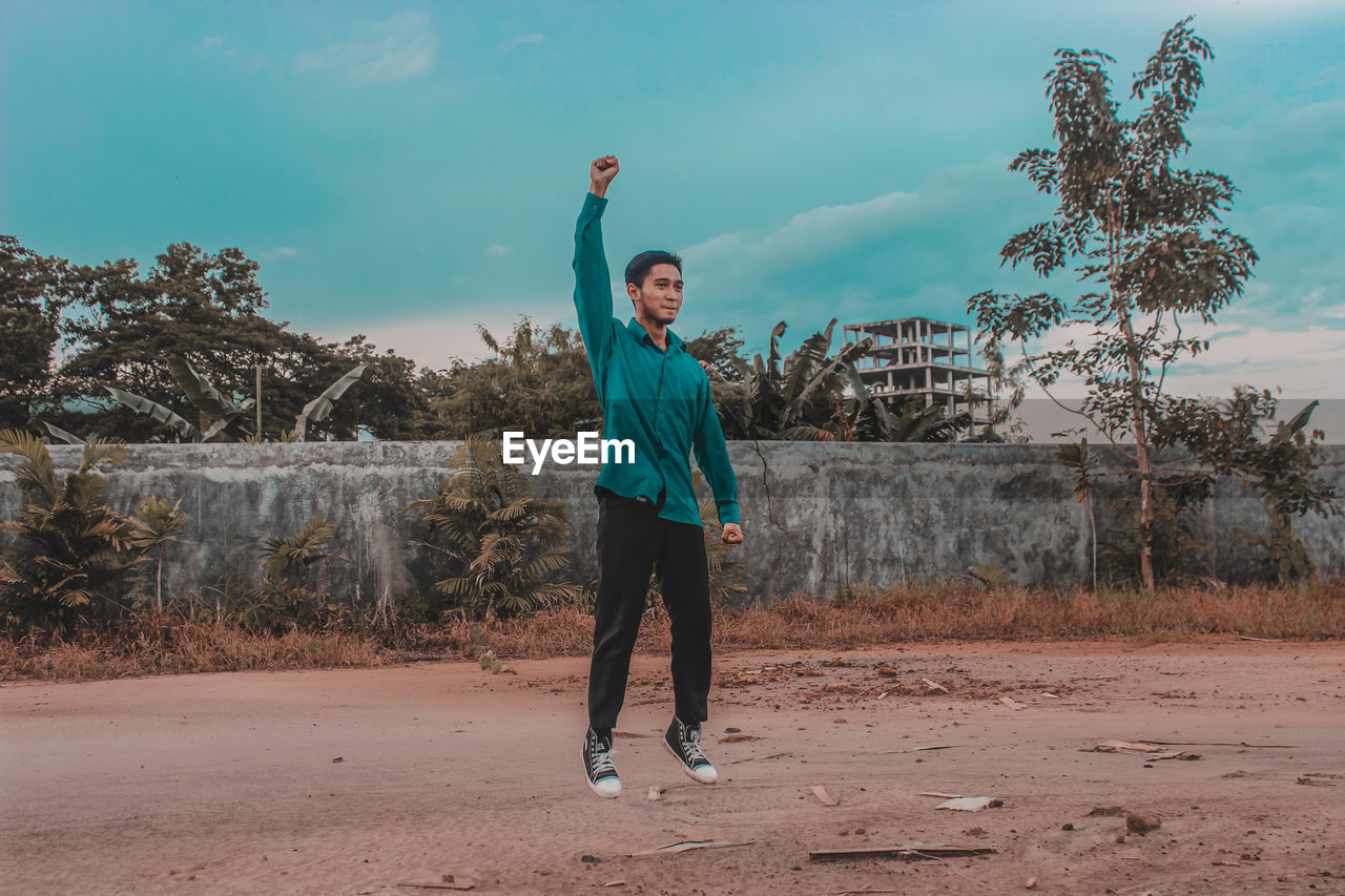 Full length of man standing on street against sky