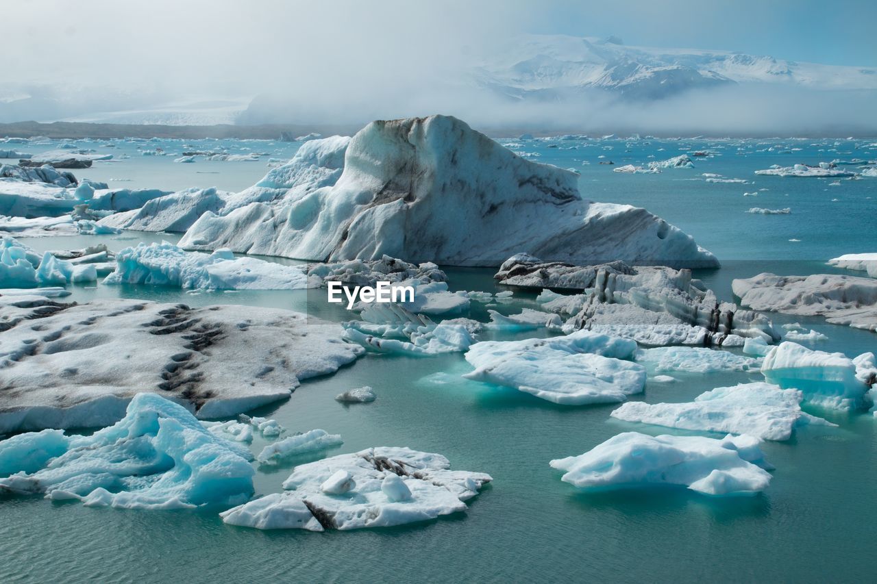 FROZEN LAKE AGAINST SKY DURING WINTER