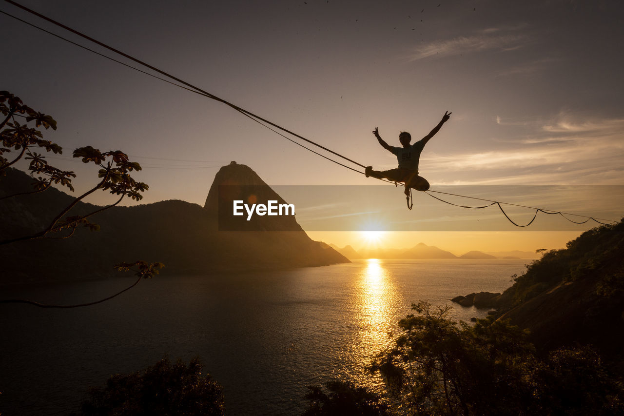 Beautiful sunrise view of man walking on highline with sugar loaf